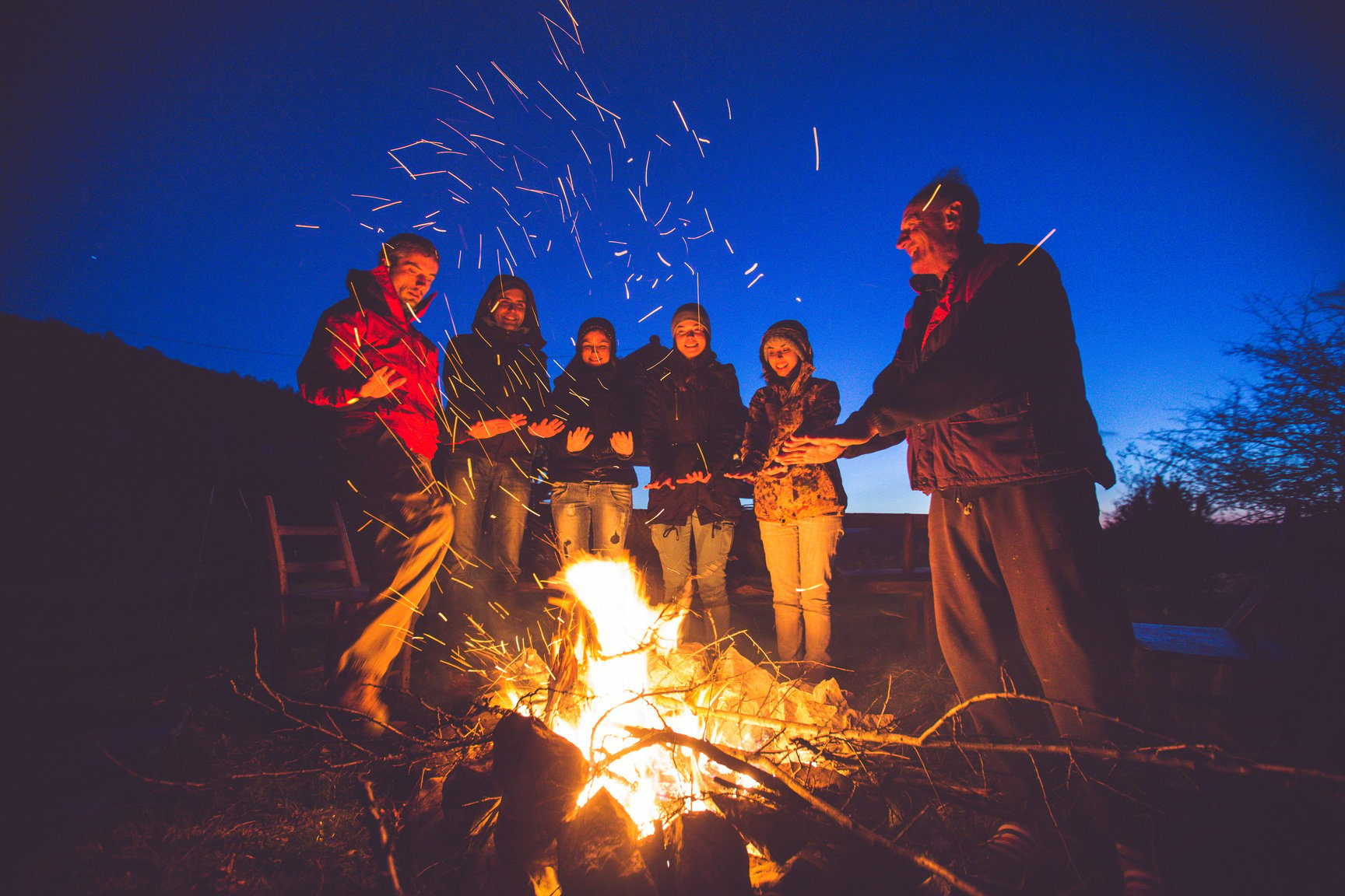 Friends near campfire